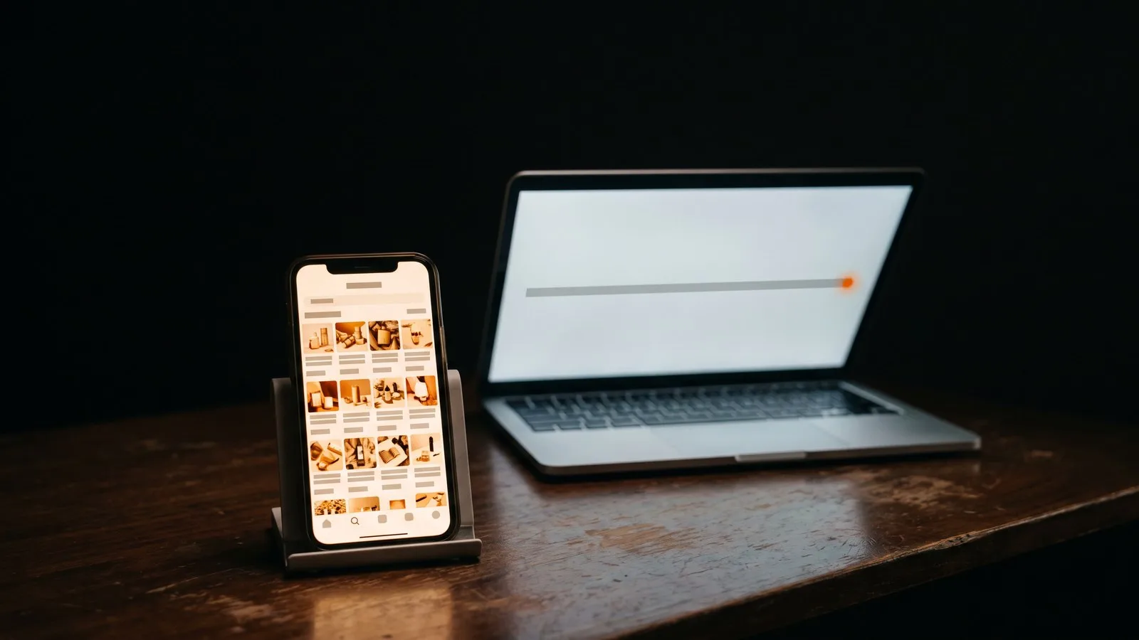 A phone showing a busy online shop beside a laptop showing a single flat analytics line with one ember dot at its end